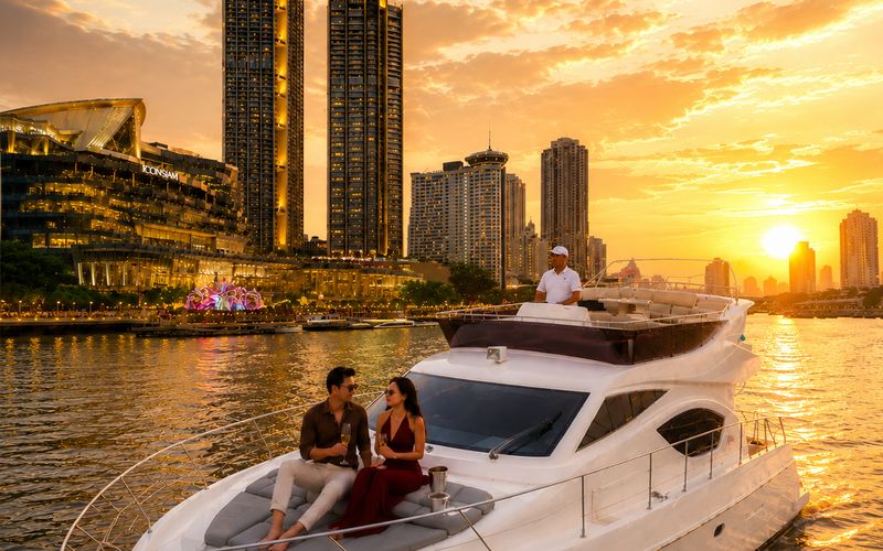 Guests aboard a Flow Yacht Club charter on the Chao Phraya at sunset